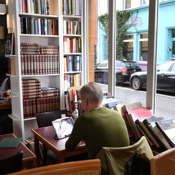 Besucherin sitzt im Café Goldmund in Ehrenfeld an einem Tisch und liest.