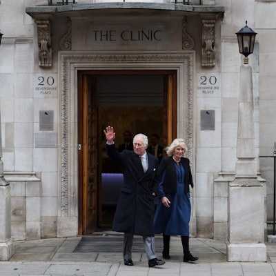 König Charles winkt neben seiner Frau Königin Camilla beim Verlassen der Klinik.