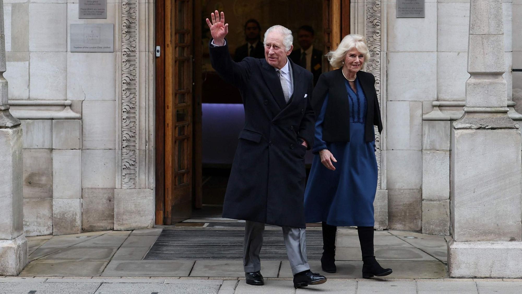 König Charles winkt neben seiner Frau Königin Camilla beim Verlassen der Klinik.