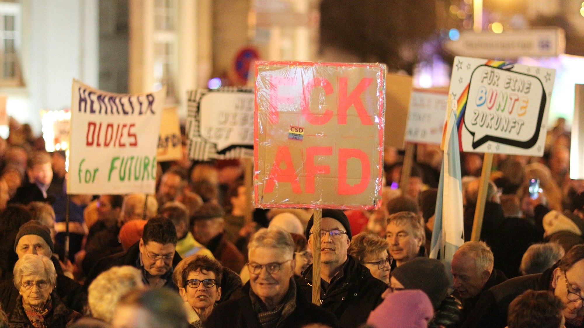Menschen halten bei einer Demonstration Schilder in die Luft.