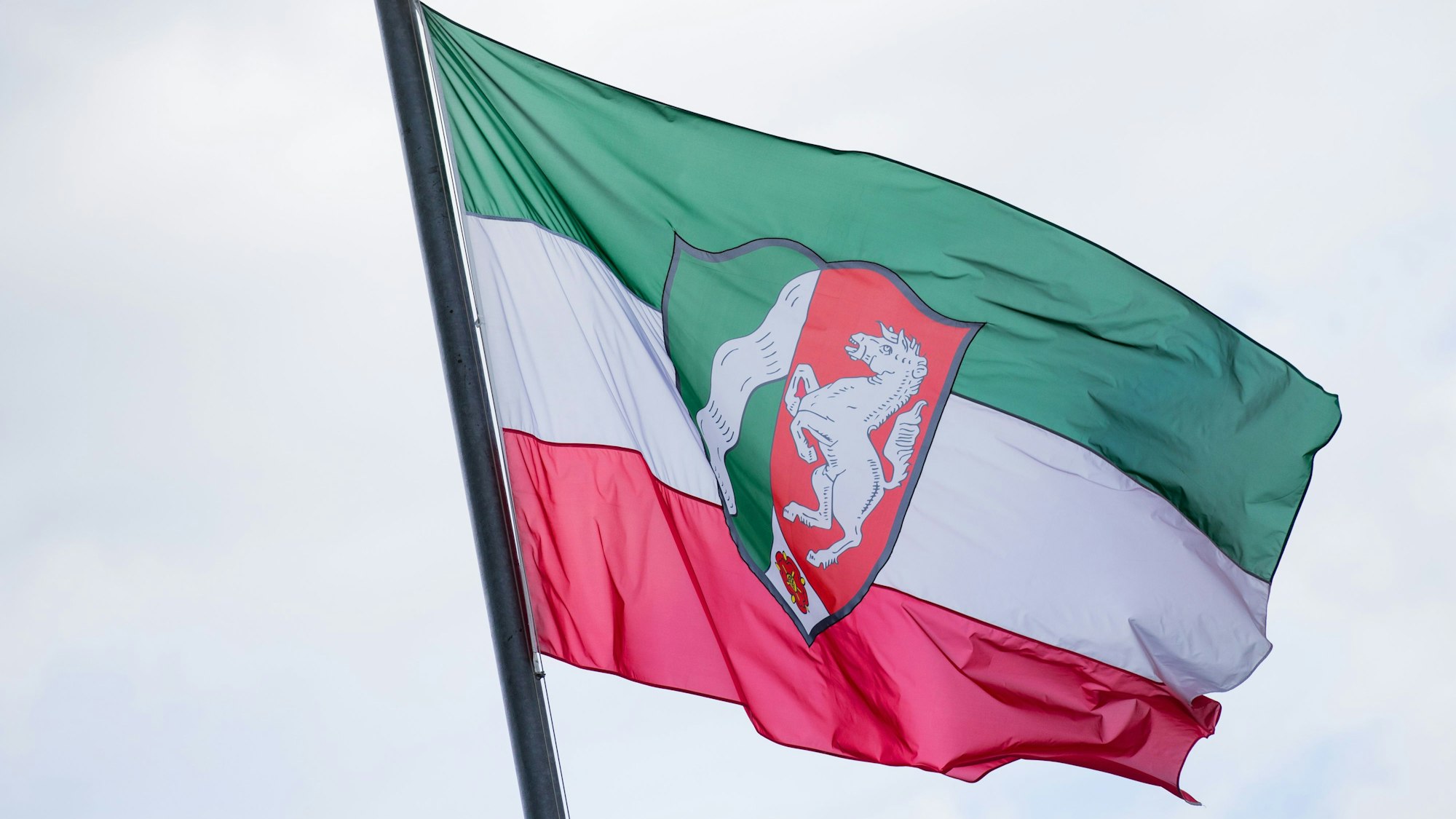 Eine Flagge mit dem Landeswappen von Nordrhein-Westfalen weht vor der Staatskanzlei in Düsseldorf.
