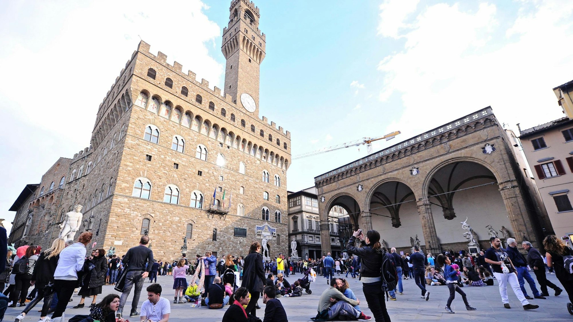 Touristen sitzen in Florenz (Italien) auf der Piazza della Signoria.