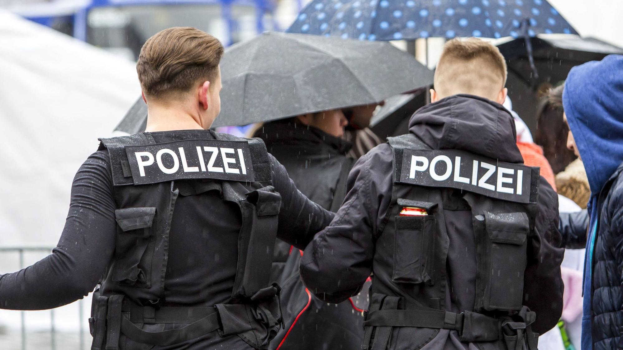 Zwei junge Männer tragen Polizei-Kostüme.