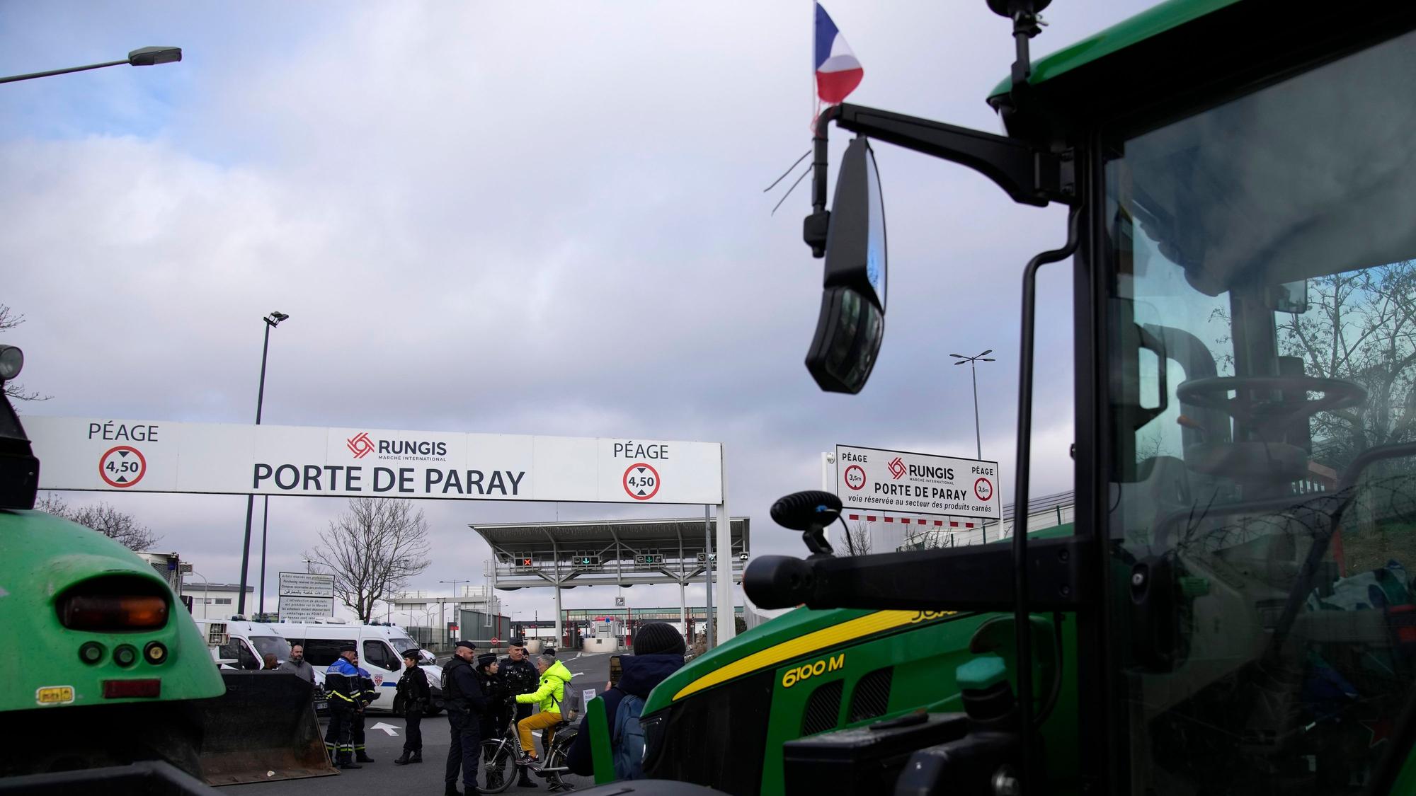 Tractors park outside the Rungis international market, which supplies the capital and surrounding region with much of its fresh food, Wednesday, Jan. 31, 2024 in Rungis, south of Paris. French farmers maintained their protests on major roads around Paris and across the country on Wednesday as police was deployed to protect the capital, its airports and an international market. (AP Photo/Christophe Ena)