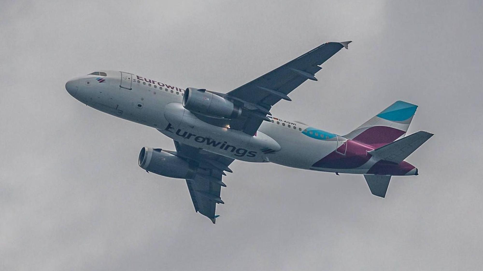 Ein Airbus A319 der deutschen Fluggesellschaft Eurowings fliegt bei aufziehendem Unwetter am Himmel. (Symbolbild)