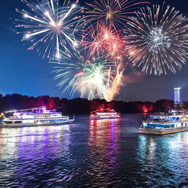 Von einem Schiffskonvoi auf dem Rhein in Bonn werden Feuerwerksraketen abgefeuert.