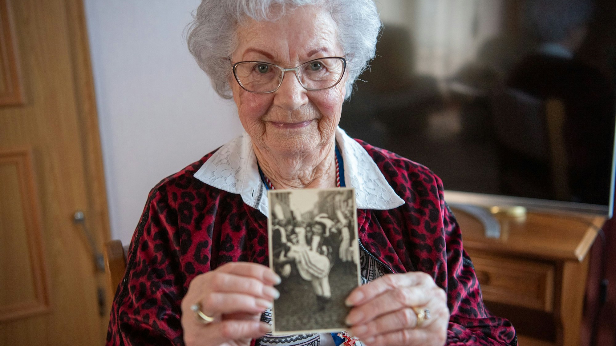Elisabeth Esser hält ein Schwarz-Weiß-Bild von sich als Tanzmariechen in die Kamera.
