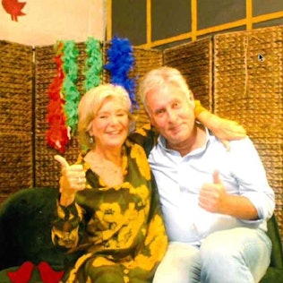 Ein Mann und eine Frau schießen ein Foto in einer Fotobox. Beide zeigen mit dem Daumen nach oben.