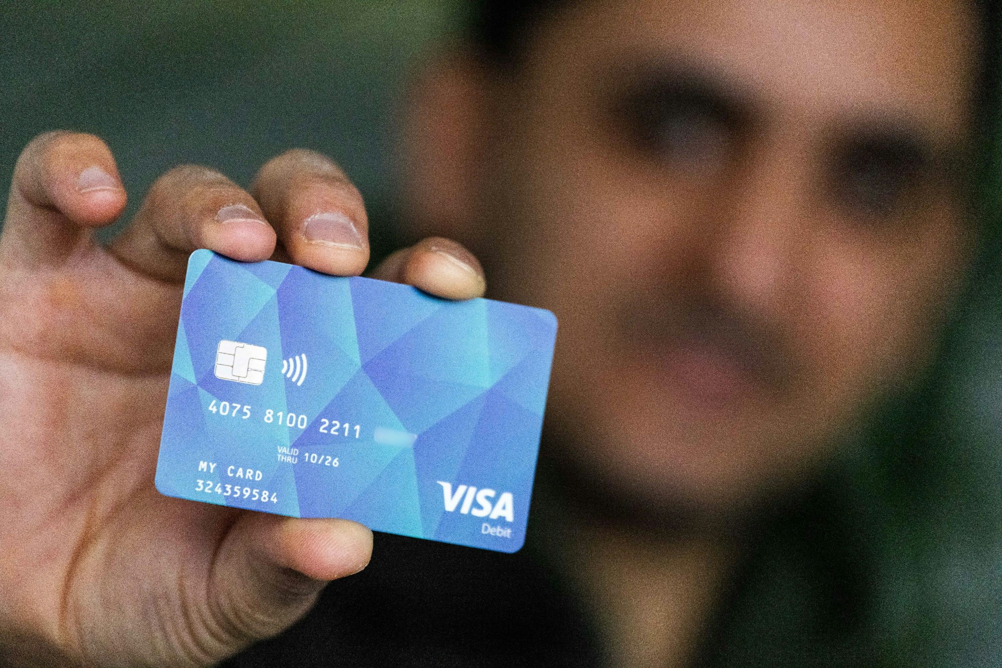 Ein Geflüchteter hält eine Debitcard in der Hand. Der Ortenaukreis zwischen Rhein und Schwarzwald will von diesem Dienstag an die ersten Bezahlkarten für Geflüchtete ausgeben.  (Zahl gepixelt.) (zu dpa: «Bezahlkarte für Flüchtlinge kommt bundesweit») Foto: Philipp von Ditfurth/dpa +++ dpa-Bildfunk +++