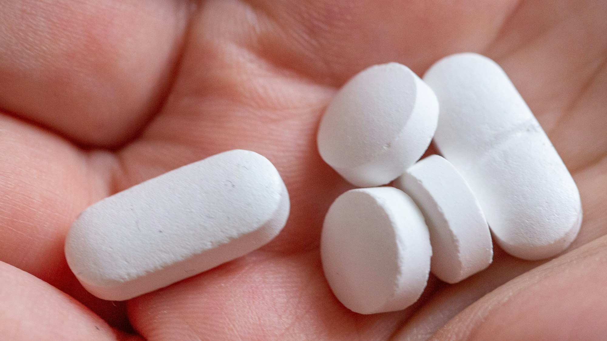 10.02.2022, Berlin: Eine Person hält Tabletten und Vitaminpräparate von Calcium, Vitamin D und Magnesium in der Hand. Viele Leute nehmen Tabletten mit Vitaminen und Mineralstoffen. Doch das ist oft unnötig.