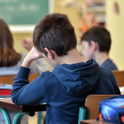 Grundschüler sitzen in einer Klasse an ihren Pulten.