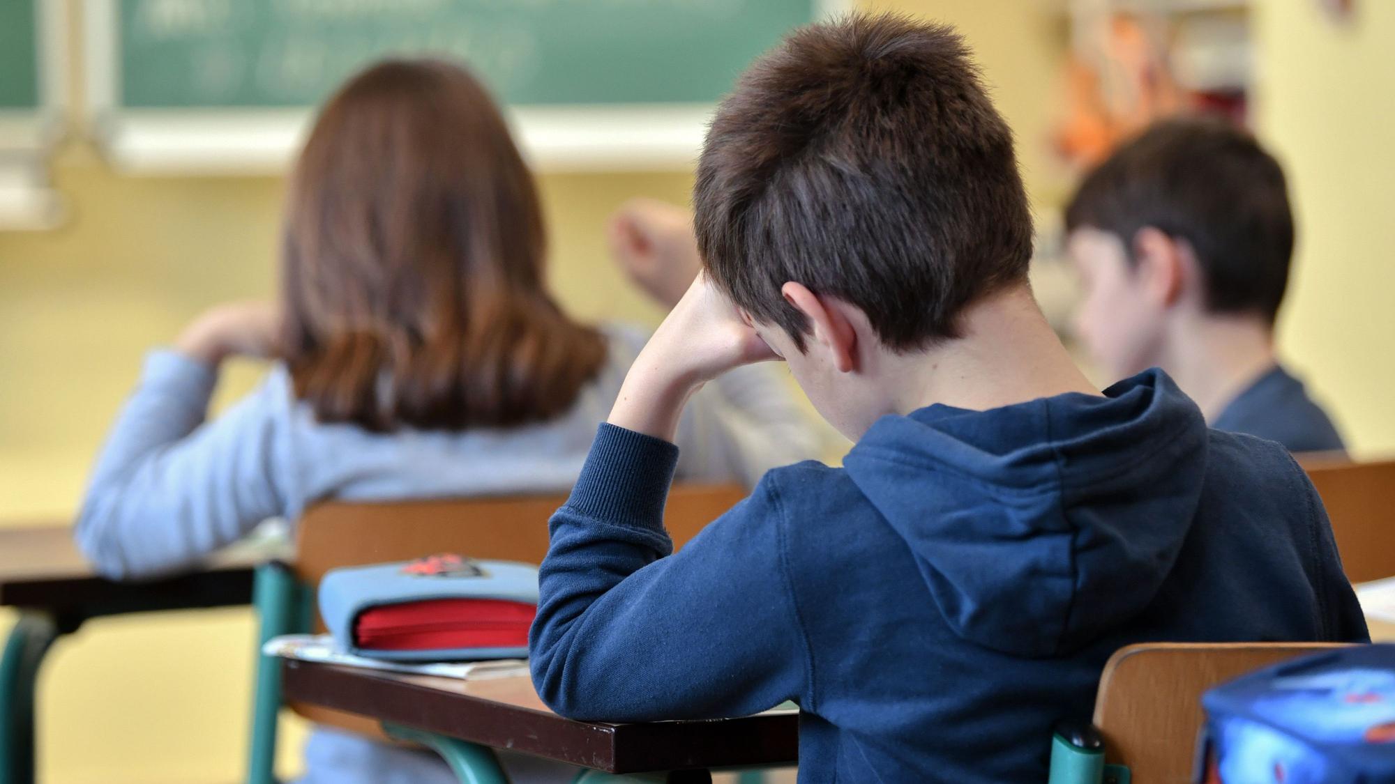 Grundschüler sitzen in einer Klasse an ihren Pulten.