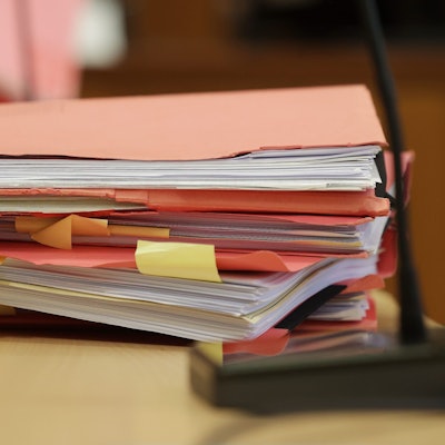 Gerichtsakten der Verteidiger liegen auf einem Tisch im Gerichtsaal.