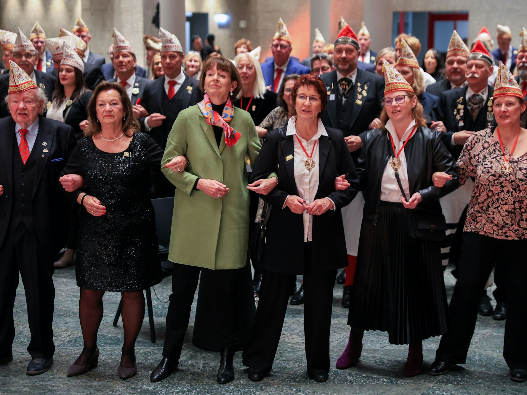 Oberbürgermeisterin Henriette Reker schunkelt mit Mitgliedern der KG UHU.