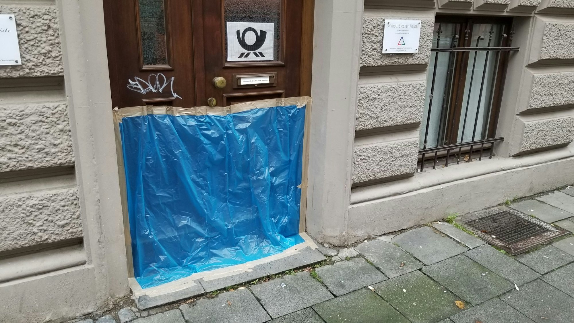 Vor einer Haustür im Zülpicher Viertel hängt am 11.11.2023 eine Plane zum Schutz vor Wildpinklern