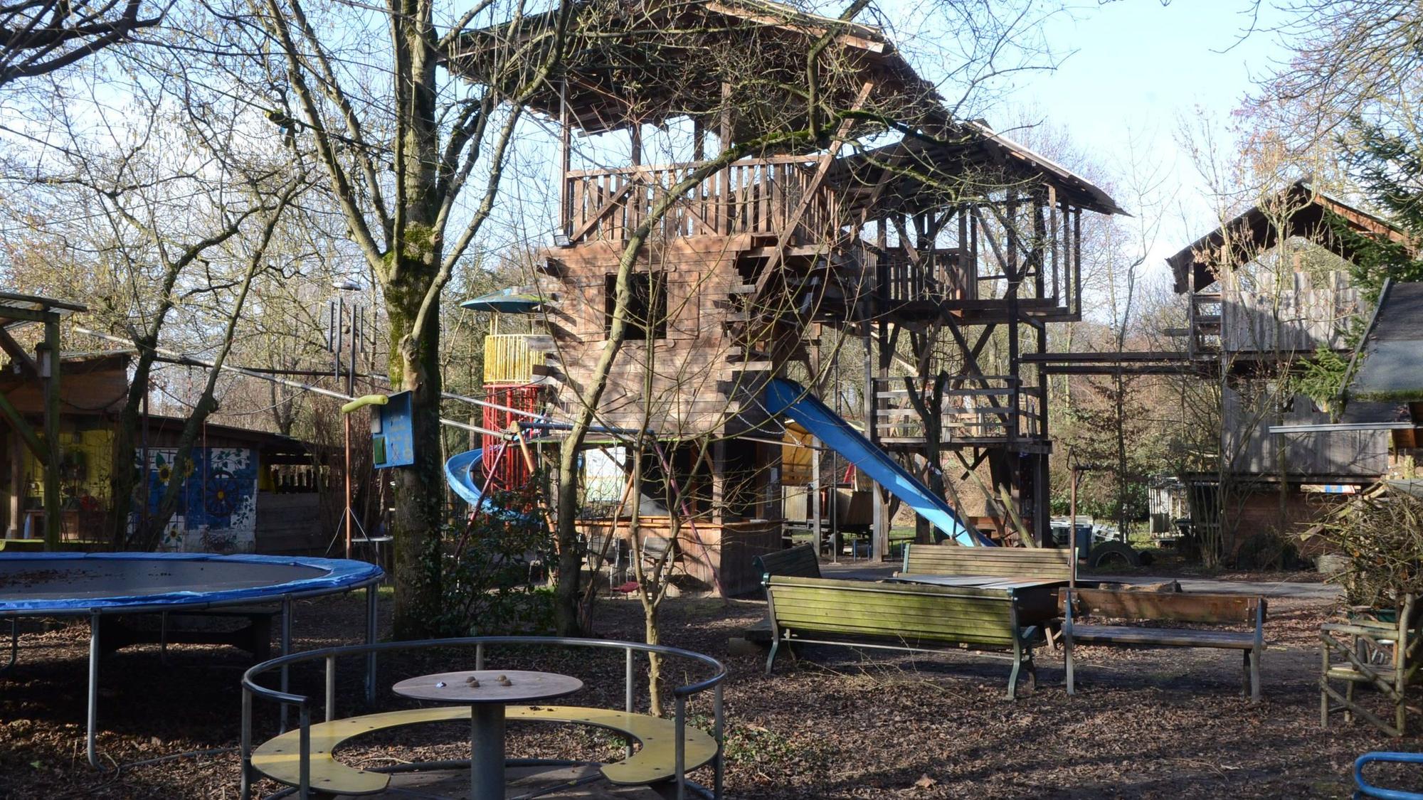 Kletterturm, Rutsche, Trampolin und Karussell auf einem Abenteuerspielplatz.