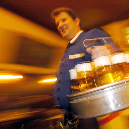 Ein Köbes in einem Kölsch-Brauhaus in der Kölner Innenstadt serviert Kölsch.