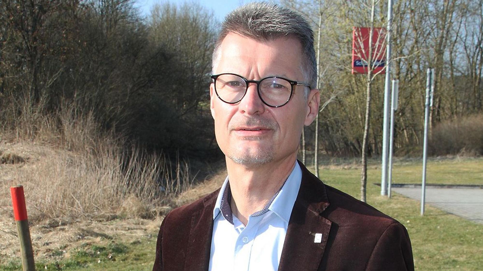 Porträtfoto von Jan Lembach. Er trägt ein braunes Sakko.