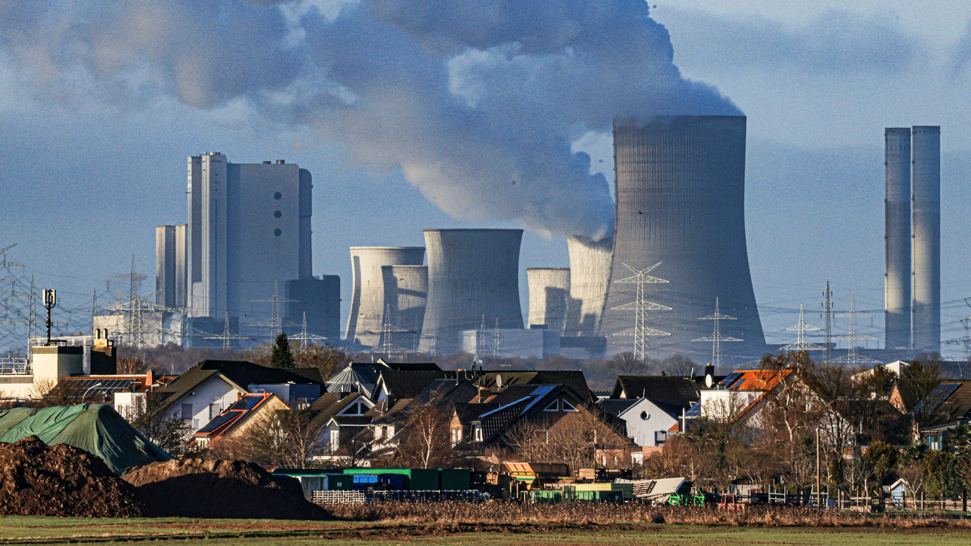 Dampf steigt aus dem RWE Braunkohlekraftwerk Niederaußem. Im Vordergrund der Pulheimer Ortsteil Sinnersdorf. Ein Teil der Blöcke des Kraftwerkes wurden bereits stillgelegt. Foto: Oliver Berg/dpa