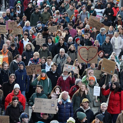 Menschen mit Transparenten laufen auf einer Demo.
