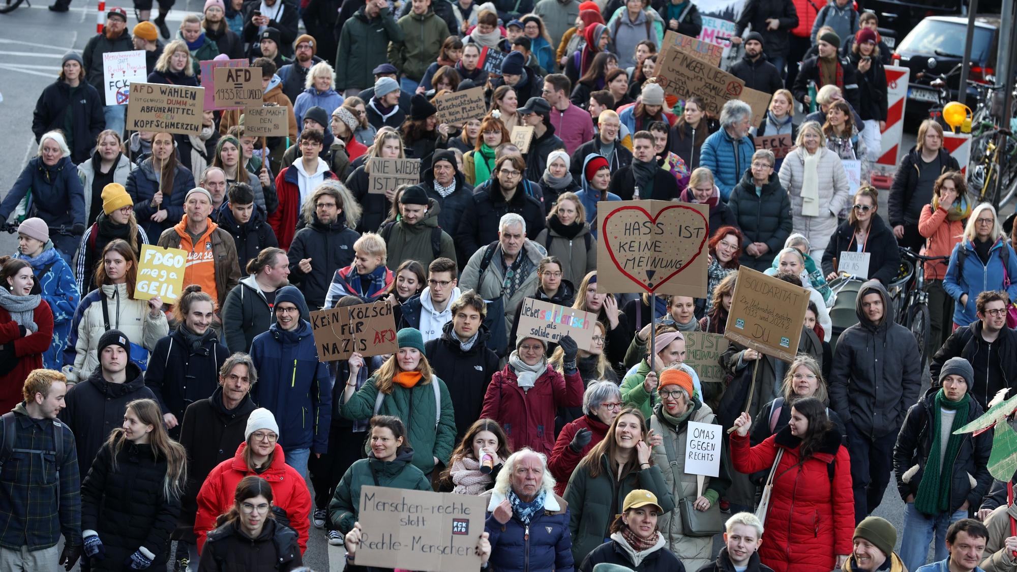 Menschen mit Transparenten laufen auf einer Demo.