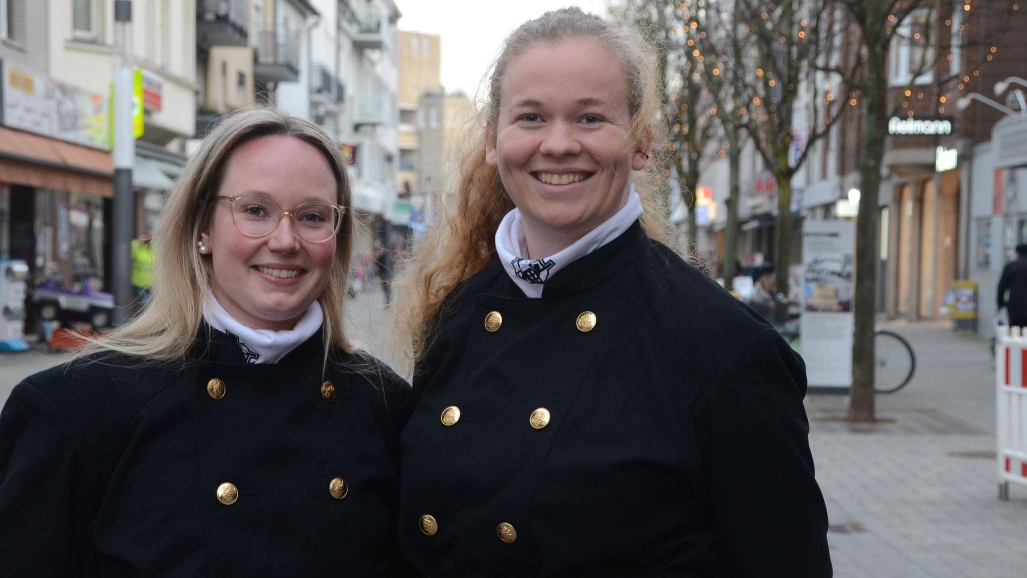 Zwei junge Frauen in Schornsteinfegerkleidung.