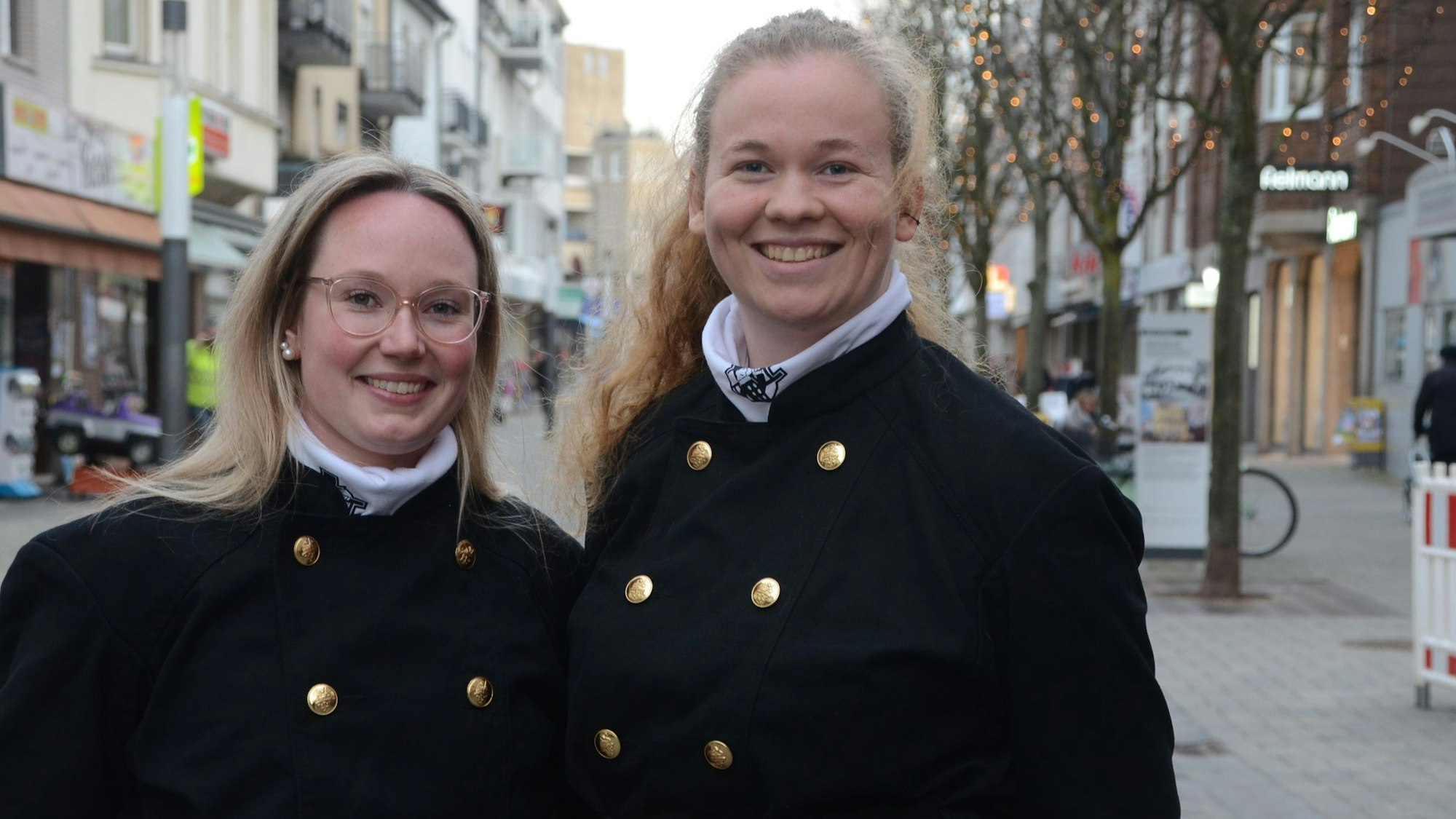 Zwei junge Frauen in Schornsteinfegerkleidung.
