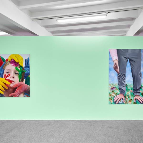 Zwei Bilder hängen an einer grünen Wand. Auf einem sind bei einem Mann Füße und Hände vertauscht.
