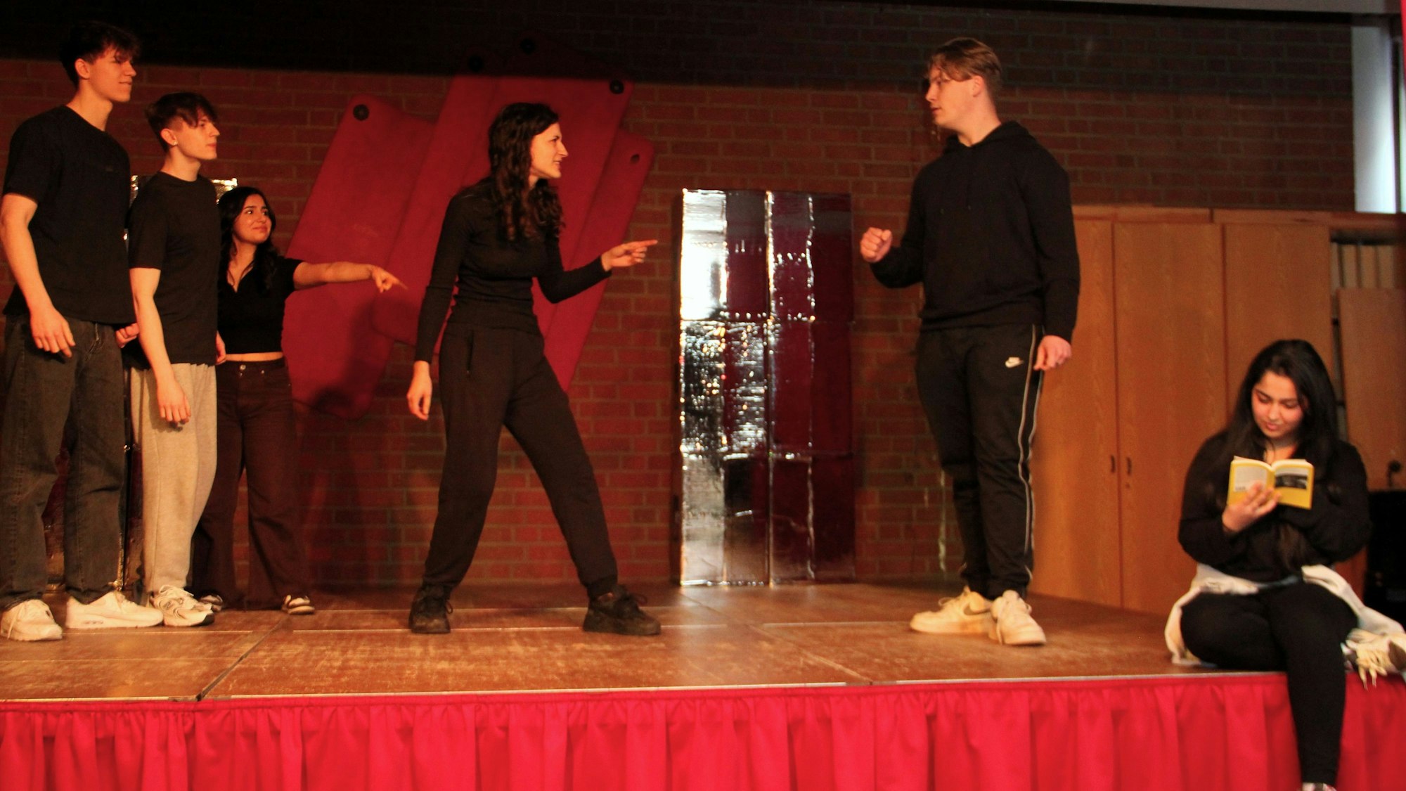 Schüler und Schülerinnen stehen auf einer Bühne.