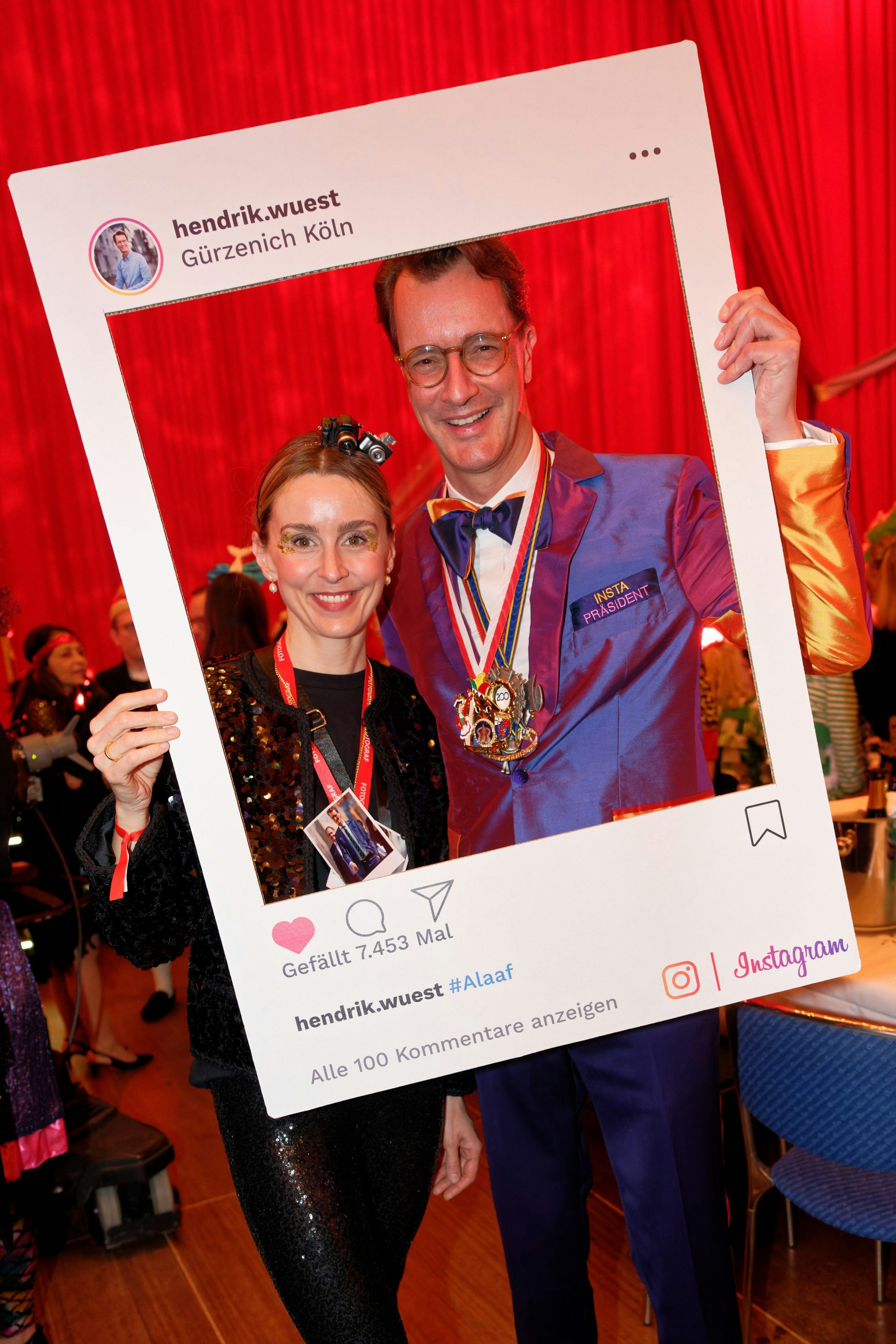 Hendrik Wüst, Ministerpräsident des Landes Nordrhein-Westfalen (CDU, l) und seine Ehefrau Katharina (r)posieren in ihrem Kostüm als „Instapräsident“ vor Beginn der WDR-Fernsehsitzung „Karneval in Köln“.