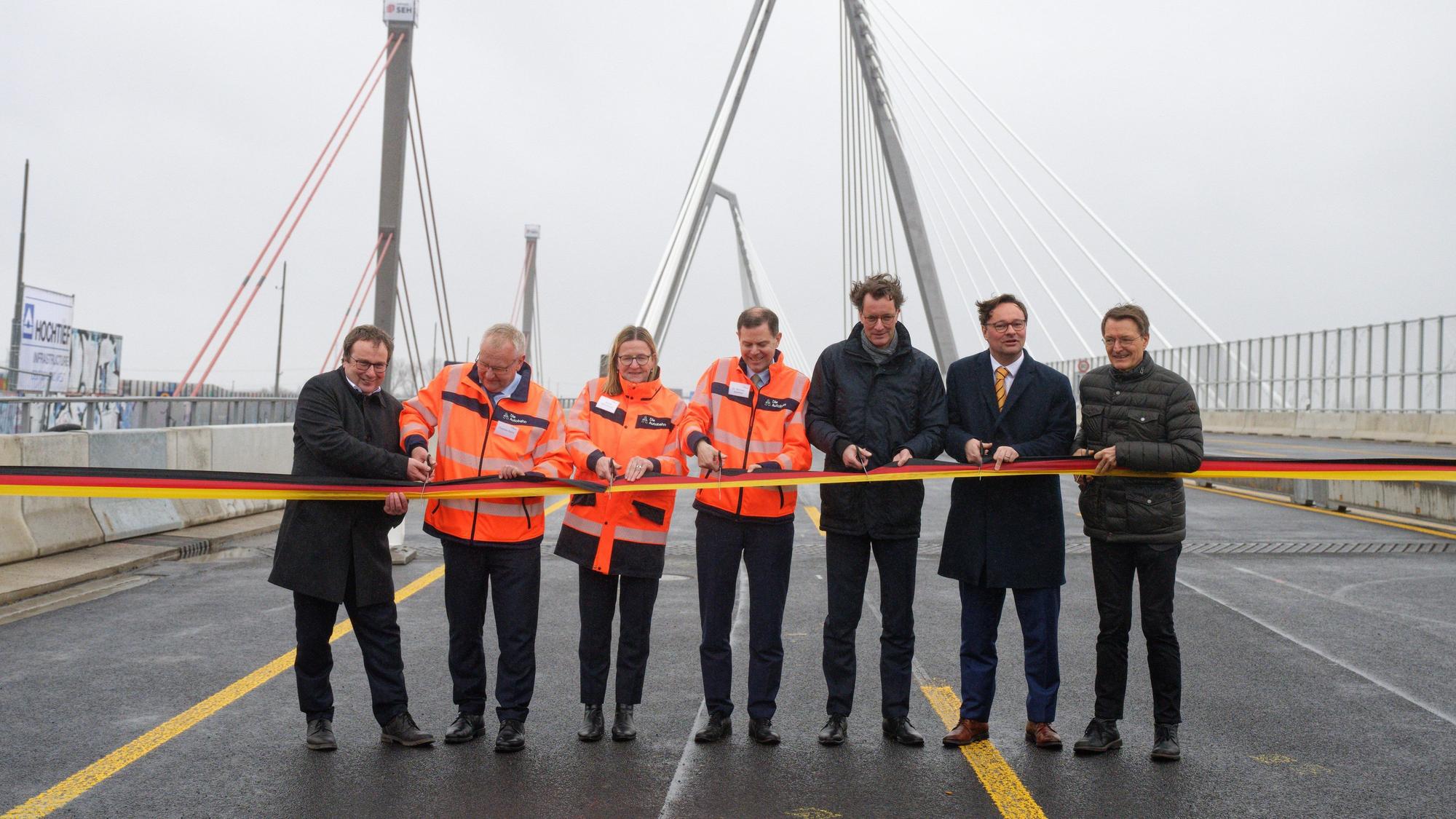 Oliver Krischer (l-r, Grüne) Verkehrsminister von Nordrhein-Westfalen, Thomas Ganz, Nicole Ritterbusch und Michael Günther, Autobahn GMBH, Hendrik Wüst (CDU), Ministerpräsident des Landes Nordrhein-Westfalen, Oliver Luksic, Staatssekretär Bundesministerium für Digitales und Verkehr, und Karl Lauterbach (r, SPD), Bundesminister für Gesundheit, sprechen bei der Verkehrsfreigabe der neuen Leverkusener Brücke mit der Presse.