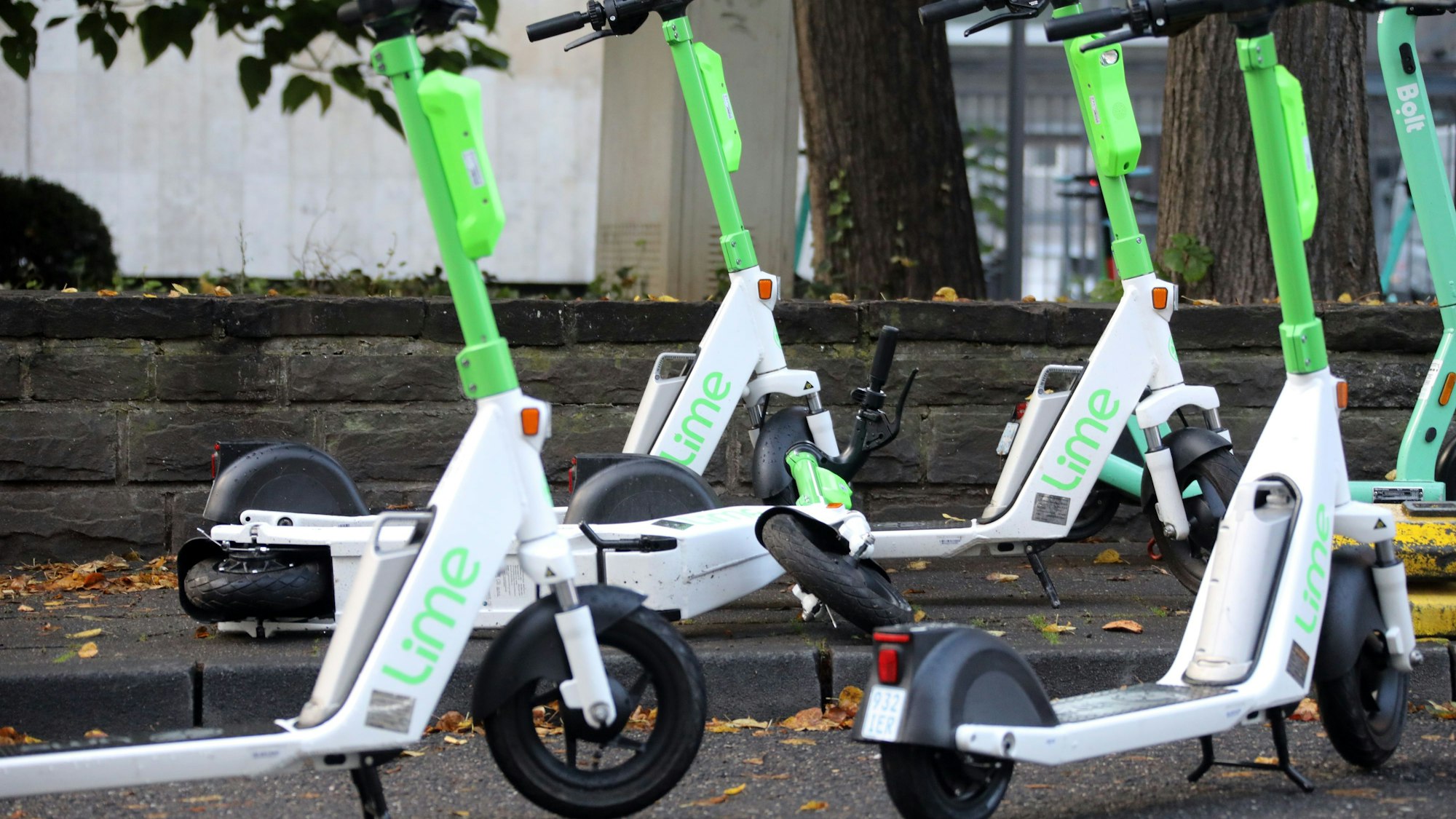 E-Scooter des Herstellers Lime sind auf dem Bürgersteig abgestellt. Foto aufgenommen im Oktober 2021.