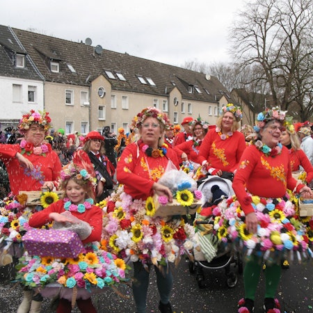 Frauen in Röcken aus bunten Blüten.