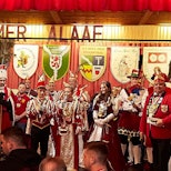 Zahlreiche Karnevalsprinzen, Prinzessinnen, Bauern und Jungfrauen stehen in ihren Kostümen auf einer Bühne.