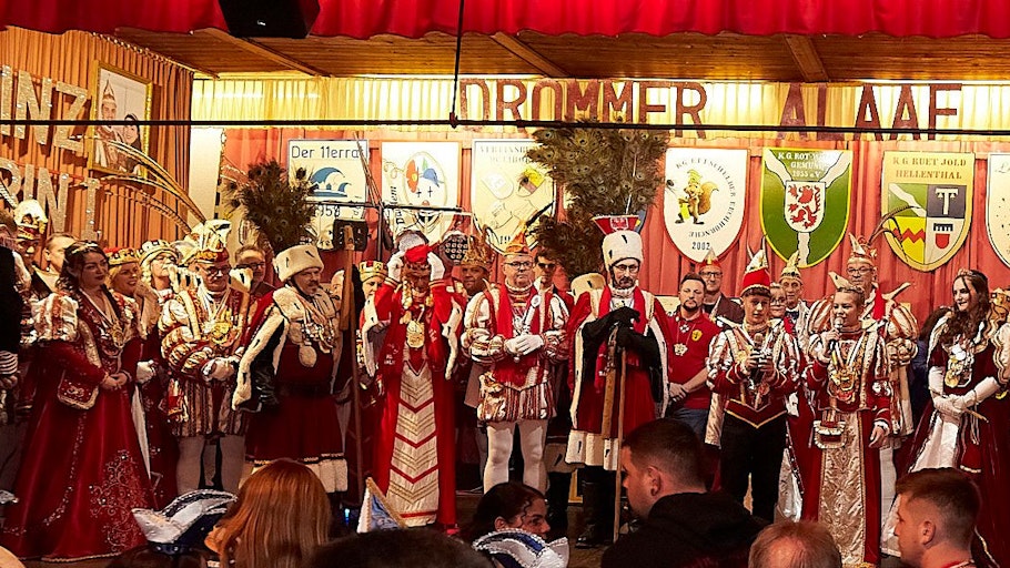 Zahlreiche Karnevalsprinzen, Prinzessinnen, Bauern und Jungfrauen stehen in ihren Kostümen auf einer Bühne.