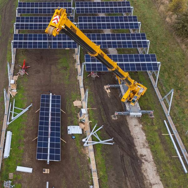 Mit einem Kran wird eine Agrar-Photovoltaik-Anlage montiert (die Aufnahme entstand mit einer Drohne). Im Wendland entsteht in einem Pilotprojekt die größte deutsche Agro-Photovoltaik-Anlage.