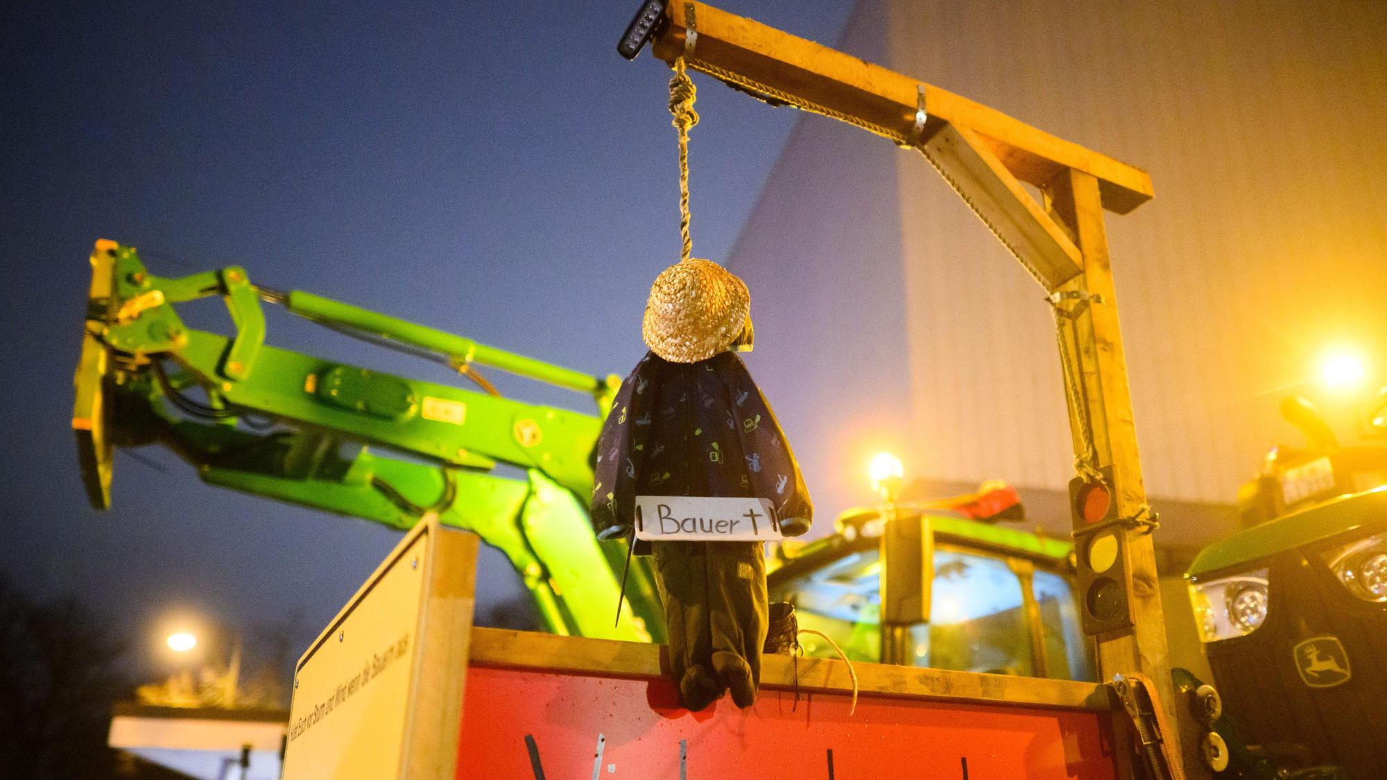 Protest vor dem NDR-Funkhaus in Hannover: Eine kleine Bauernpuppe hängt an einem Galgen mit Ampel-Symbol.