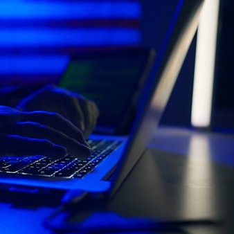 Eine Person sitzt an einem Laptop. Betrüger sollen in Hongkong mithilfe von KI-Deepfake rund 23 Millionen Euro erbeutet haben. (Symbolbild)