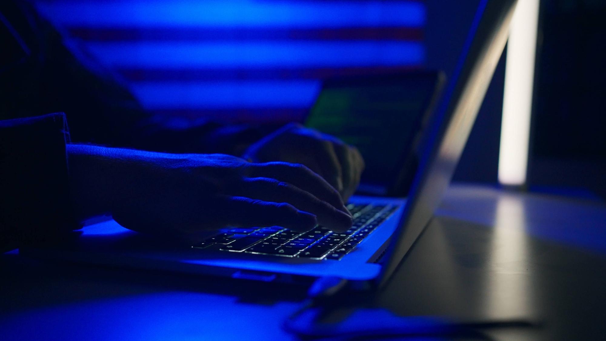 Eine Person sitzt an einem Laptop. Betrüger sollen in Hongkong mithilfe von KI-Deepfake rund 23 Millionen Euro erbeutet haben. (Symbolbild)