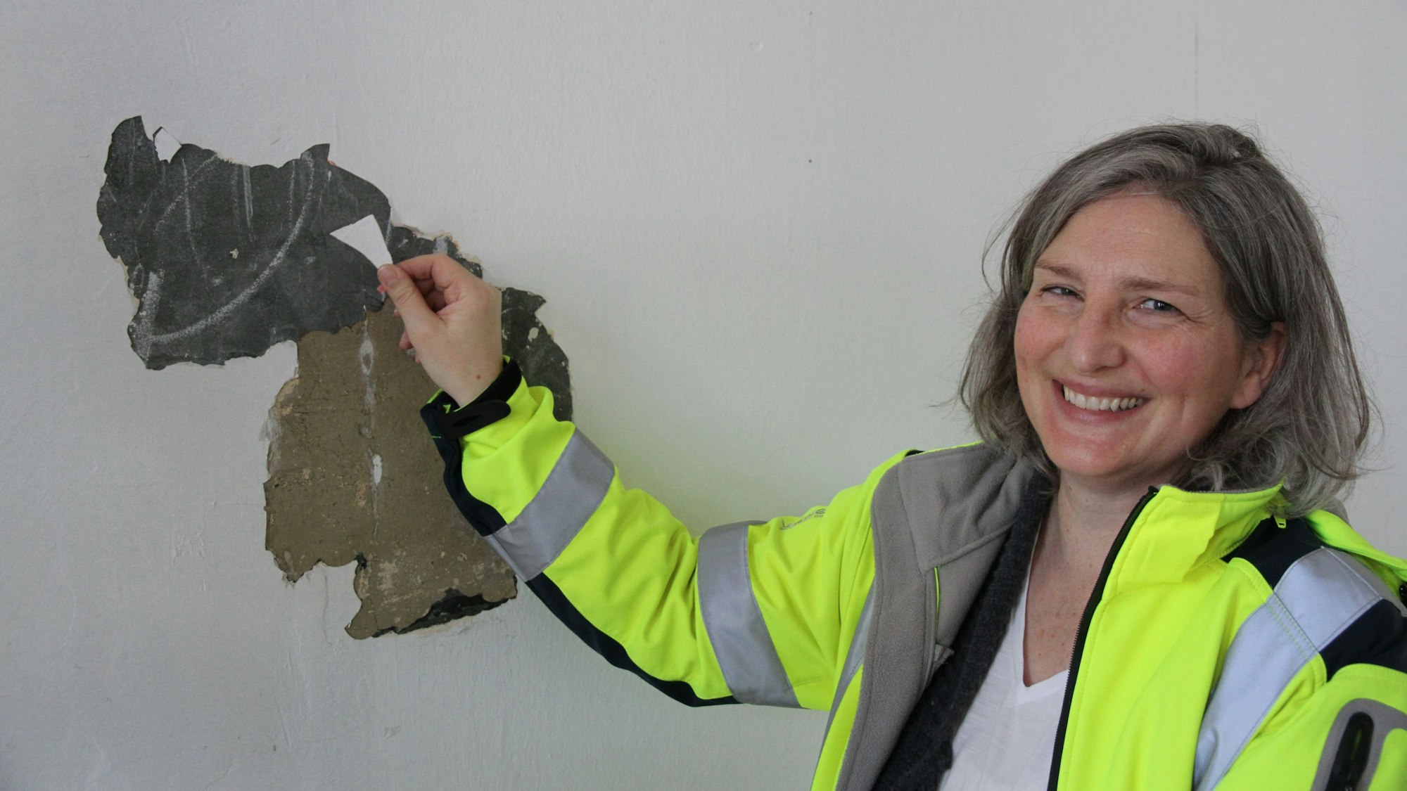 Eine Frau vor einer Wand mit einer schieferähnlichen Schicht für eine Schultafel