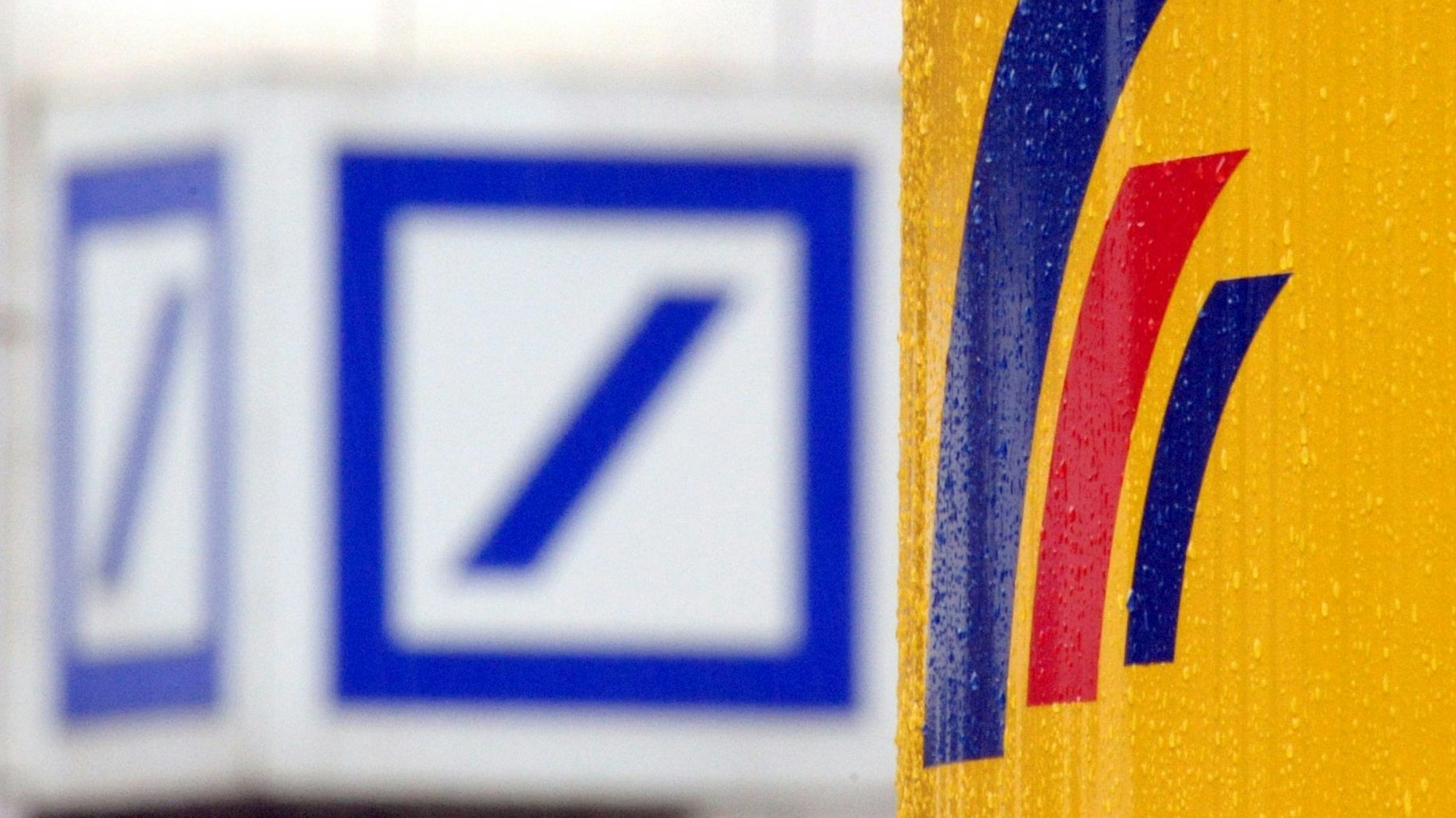 ARCHIV - 12.09.2008, Nordrhein-Westfalen, Bonn: Das Logo der Deutschen Bank hängt gegenüber dem Logo der Postbank. (zu dpa: «Alarmanlage defekt - Filialen von Deutscher und Postbank zeitweise zu») Foto: Federico Gambarini/dpa +++ dpa-Bildfunk +++