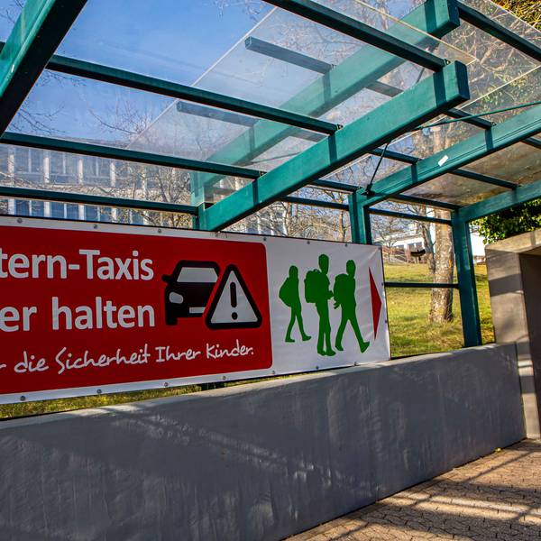 Ein Transparent mit der Aufschrift „Elterntaxis hier halten“.