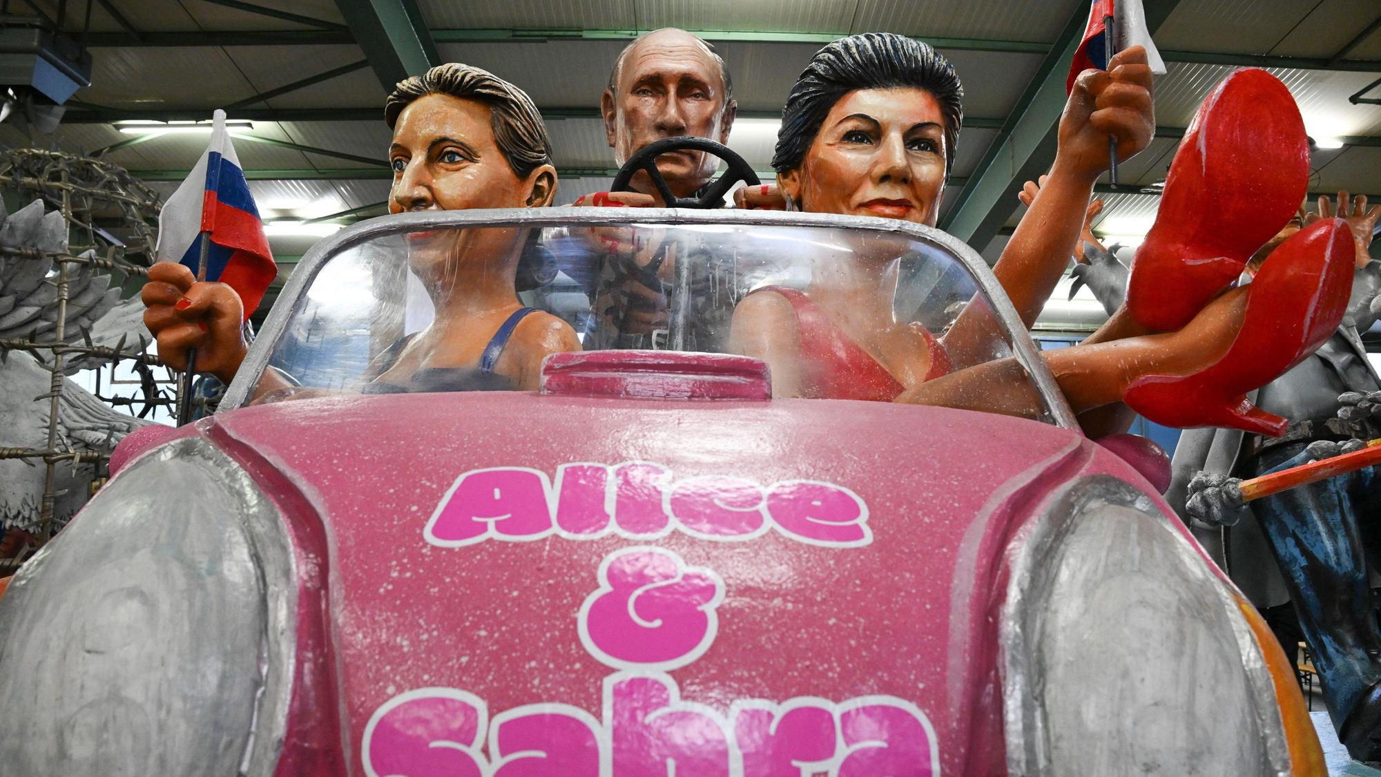 Der russische Präsident Wladimir Putin (M), Alice Weidel (AfD, l) und Sahra Wagenknecht (BSW) werden als Barbies und Ken bei der Vorstellung der Motivwagen für den Mainzer Rosenmontagszug in der Wagenhalle des Mainzer Carneval-Vereins (MCV) präsentiert.