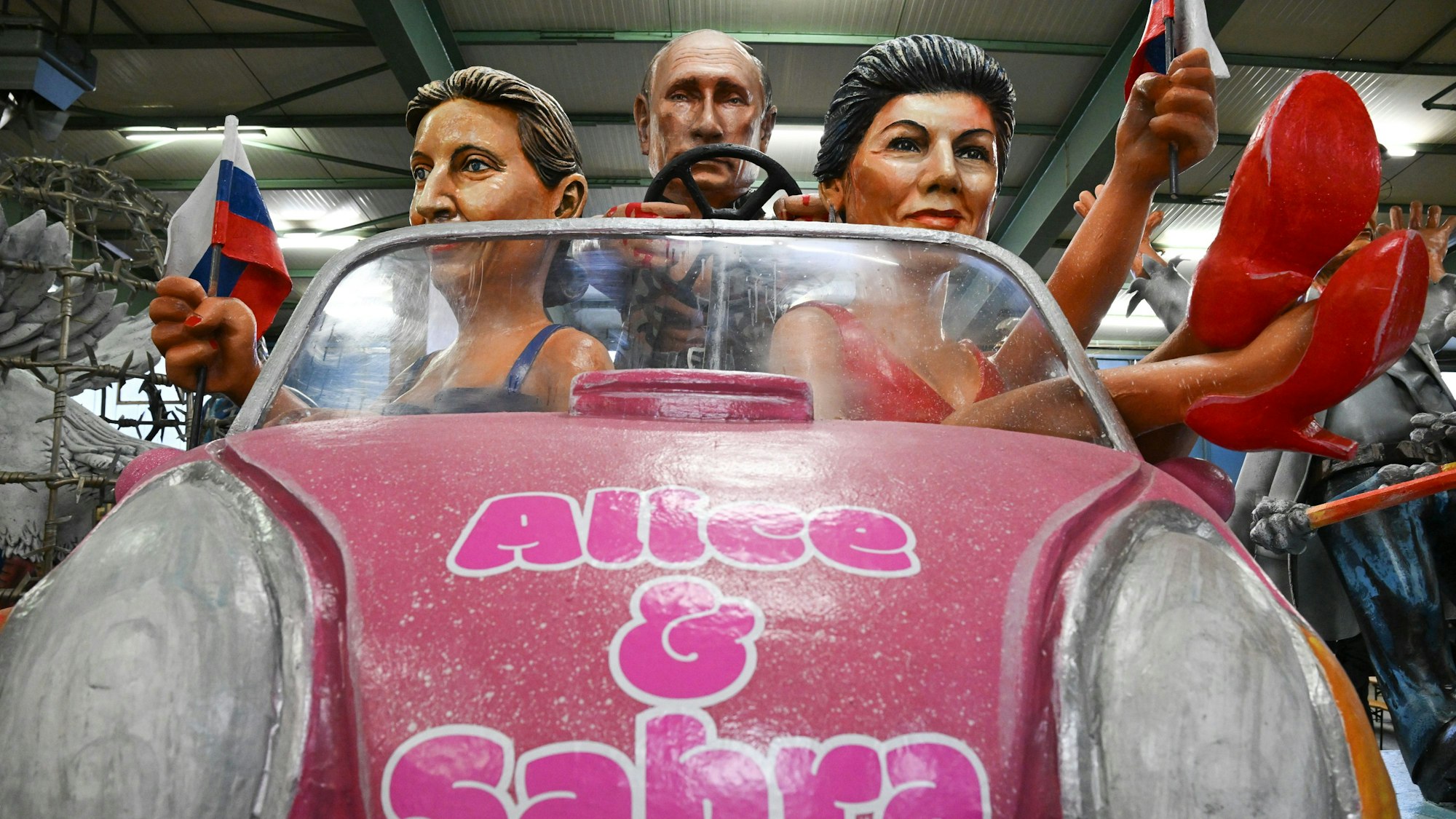 Der russische Präsident Wladimir Putin (M), Alice Weidel (AfD, l) und Sahra Wagenknecht (BSW) werden als Barbies und Ken bei der Vorstellung der Motivwagen für den Mainzer Rosenmontagszug in der Wagenhalle des Mainzer Carneval-Vereins (MCV) präsentiert.