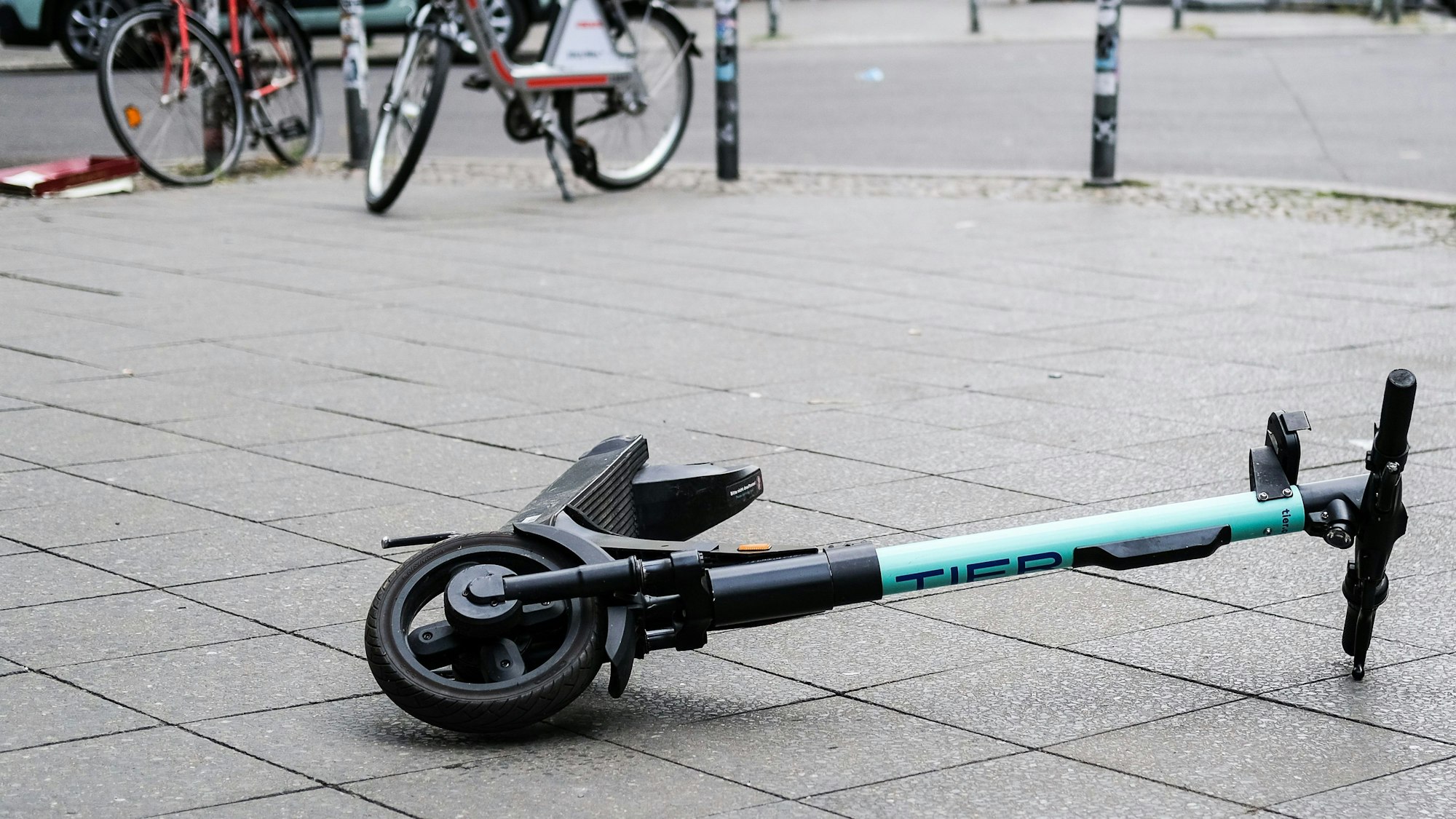 Ein E-Scooter liegt umgekippt mitten auf dem Gehweg (Symbolbild)dpa