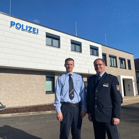 Zu sehen sind zwei Polizeibeamte vor der neuen Wache in Brühl.