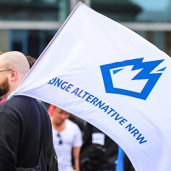 Ein Mitglied der «Jungen Alternative» (JA), Jugendorganisation der AfD, trägt auf einer Wahlkampfveranstaltung eine Fahne mit dem Logo der Organisation.