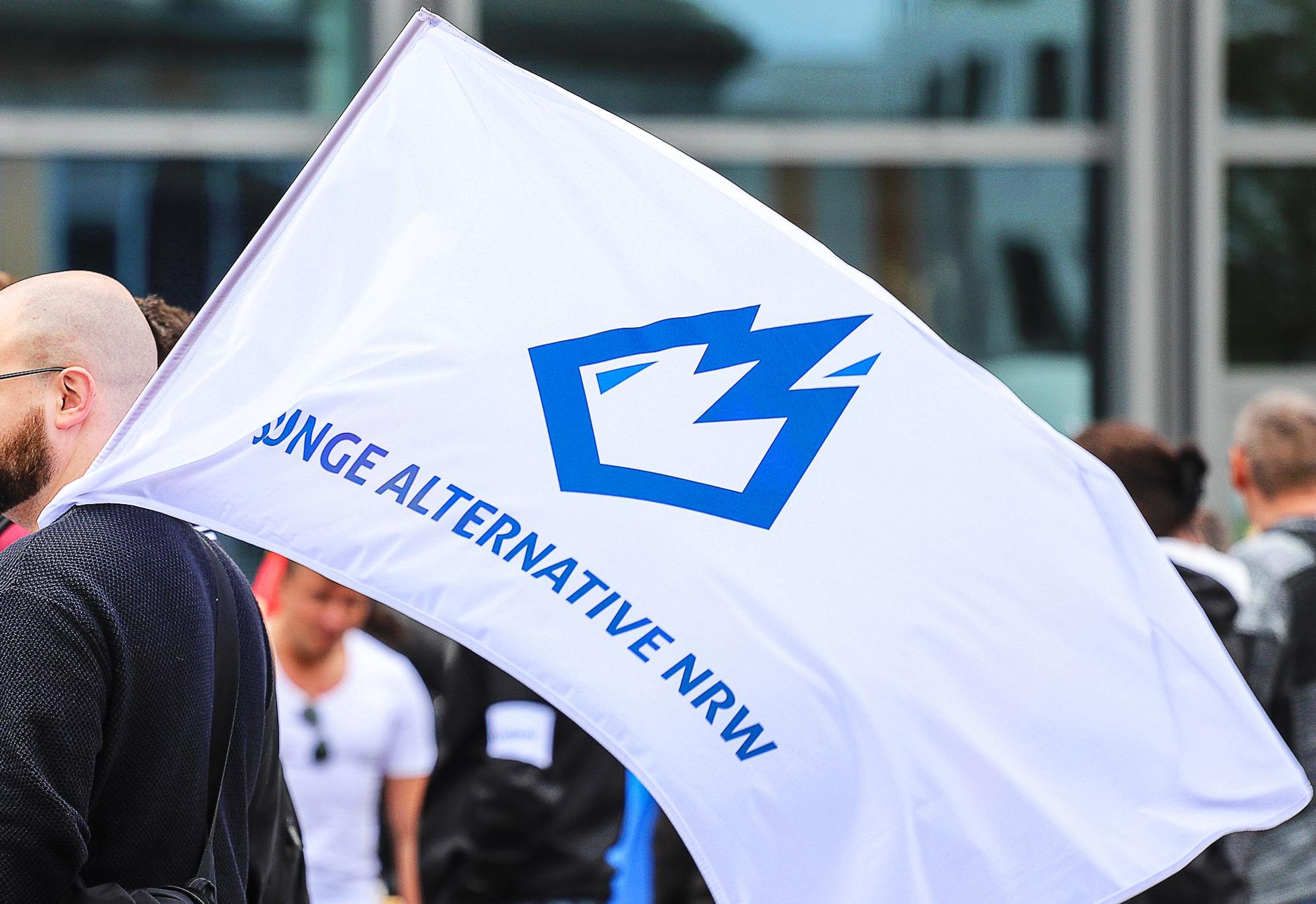 Ein Mitglied der «Jungen Alternative» (JA), Jugendorganisation der AfD, trägt auf einer Wahlkampfveranstaltung eine Fahne mit dem Logo der Organisation.