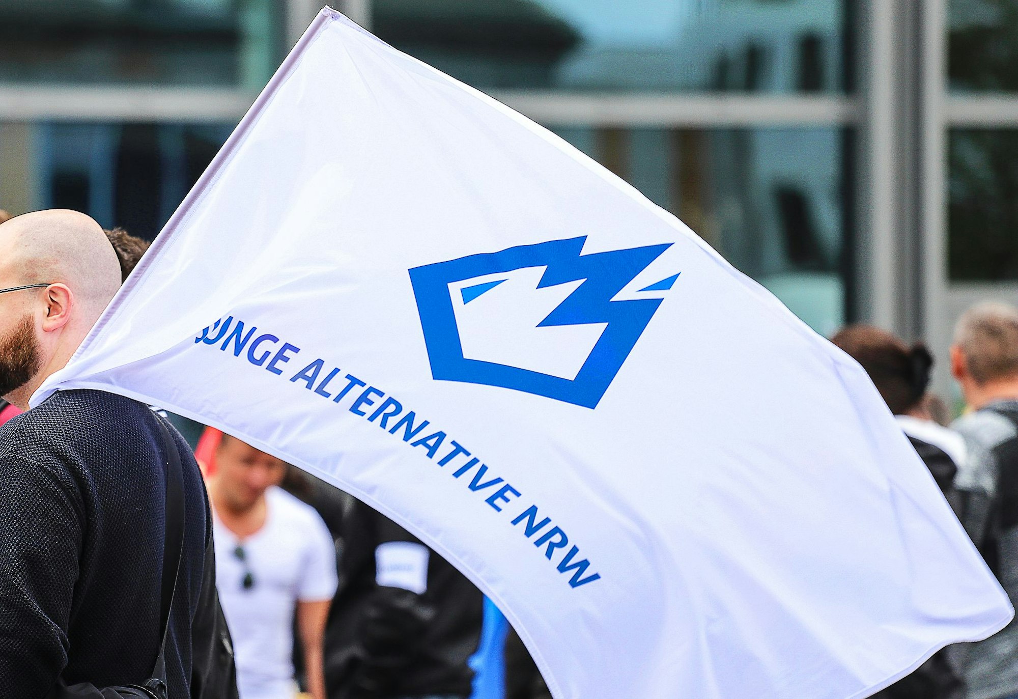 Ein Mitglied der «Jungen Alternative» (JA), Jugendorganisation der AfD, trägt auf einer Wahlkampfveranstaltung eine Fahne mit dem Logo der Organisation.