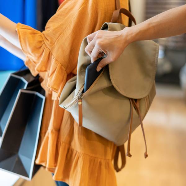 Eine Hand zieht ein Smartphone aus einer Tasche.